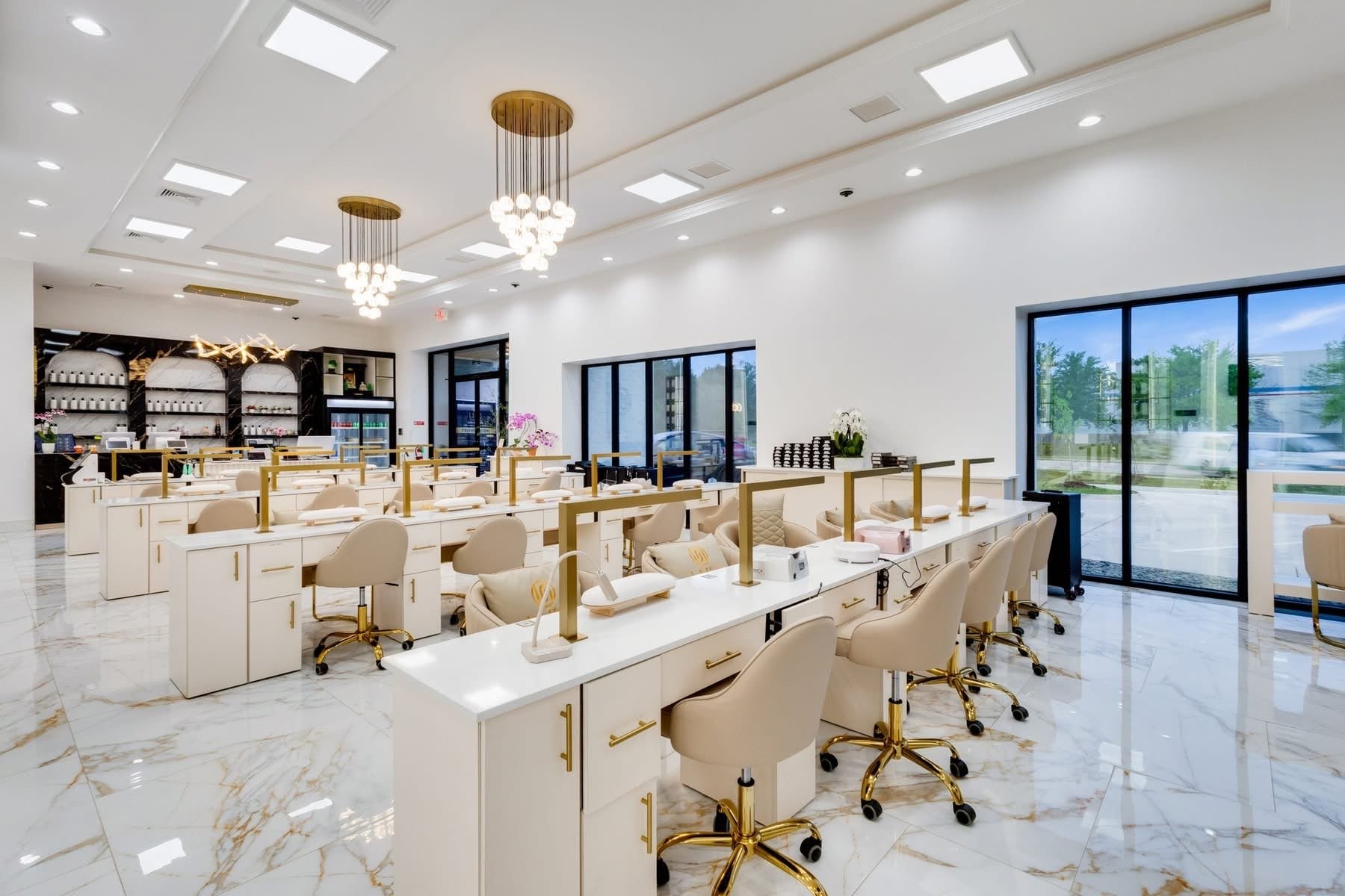 UNIQ Nail Lounge & Spa main floor with twin gold globe chandeliers and rows of manicure stations