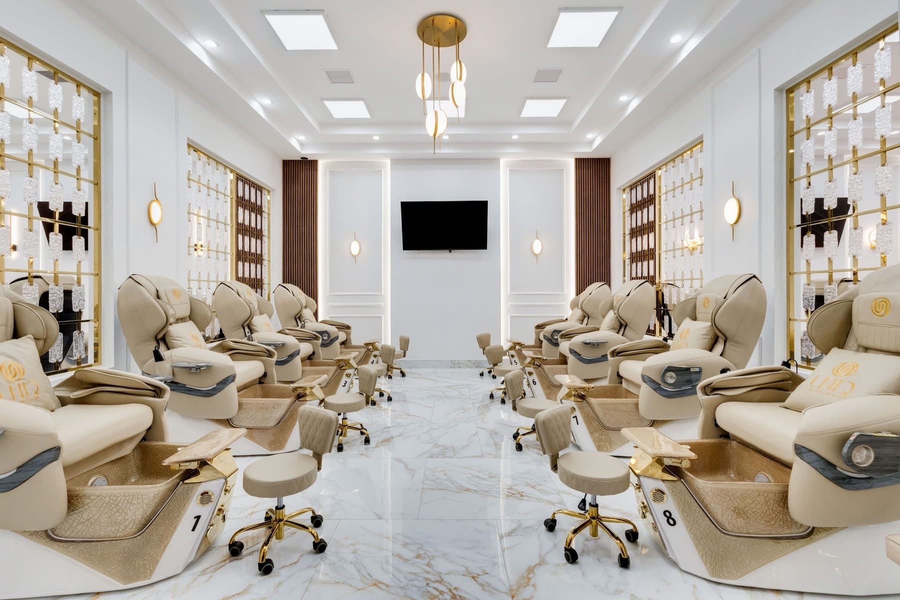 UNIQ Nail Lounge & Spa pedicure suite with symmetric throne arrangement and crystal-detail gold grid walls