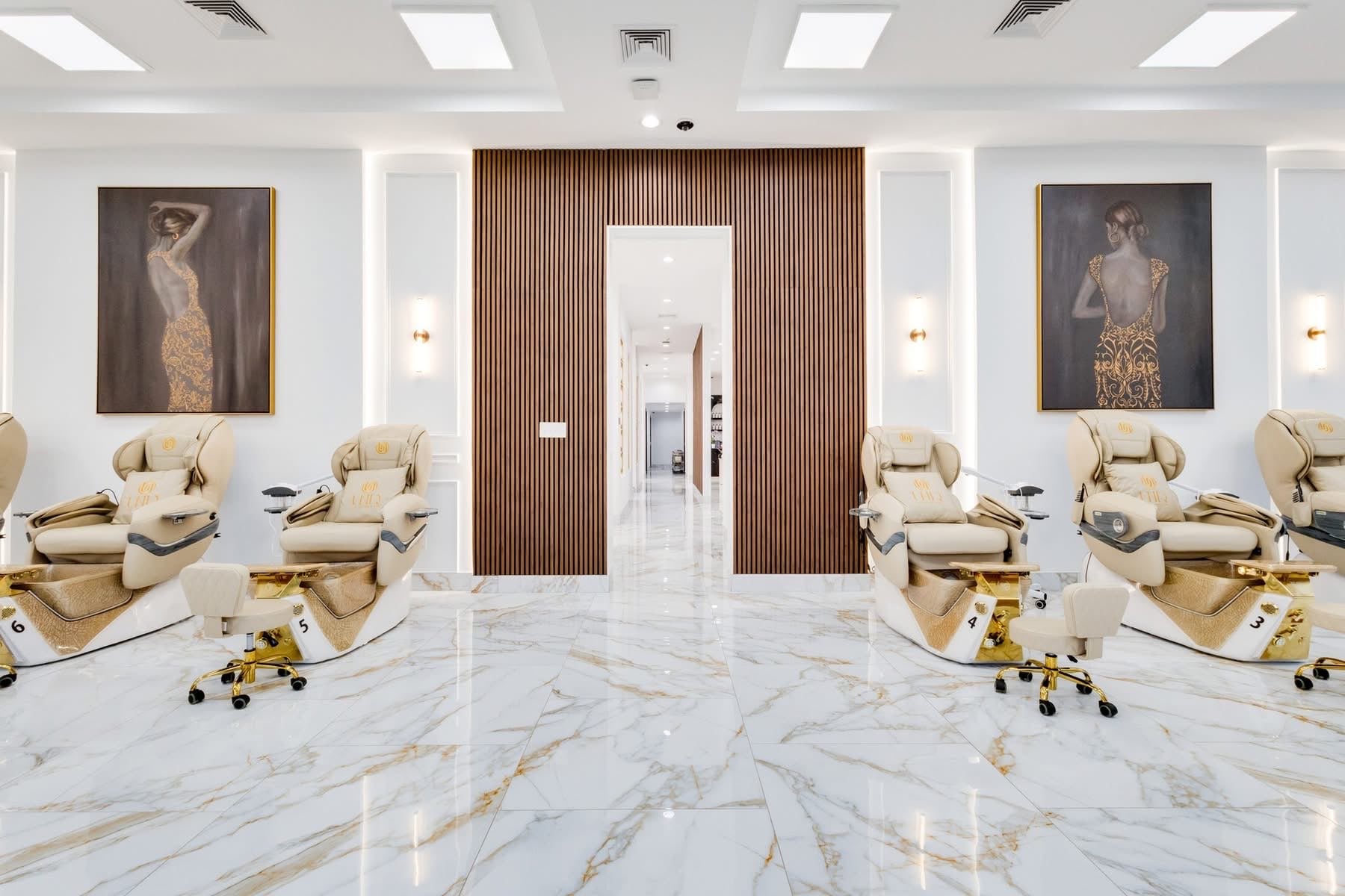 UNIQ Nail Lounge & Spa pedicure room with art-deco oil paintings and wood-slat divider wall