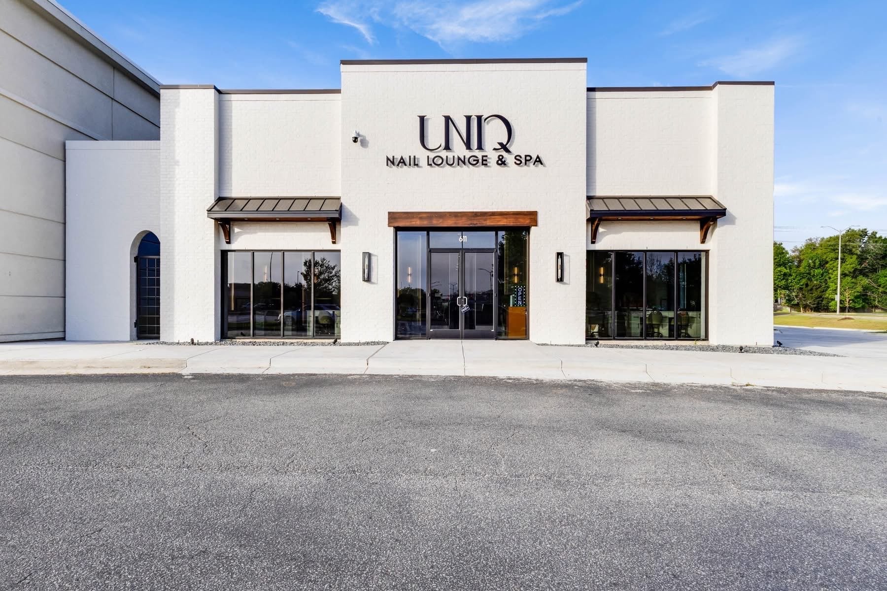 UNIQ Nail Lounge & Spa building exterior with white brick facade and signage