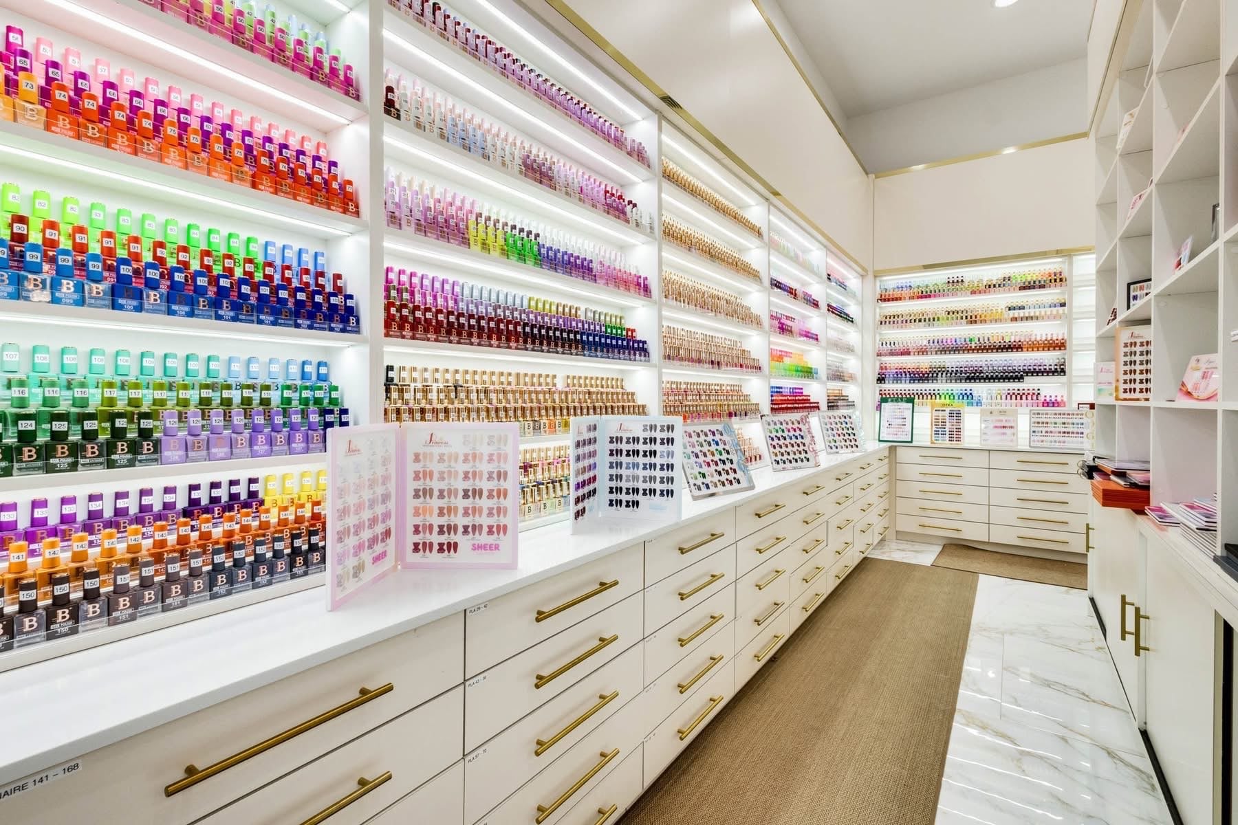 UNIQ Nail Lounge & Spa polish display wall with full-spectrum color organization